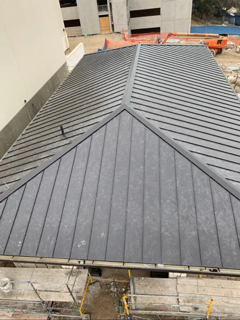 Commercial metal roof construction with crane equipment in Buxton